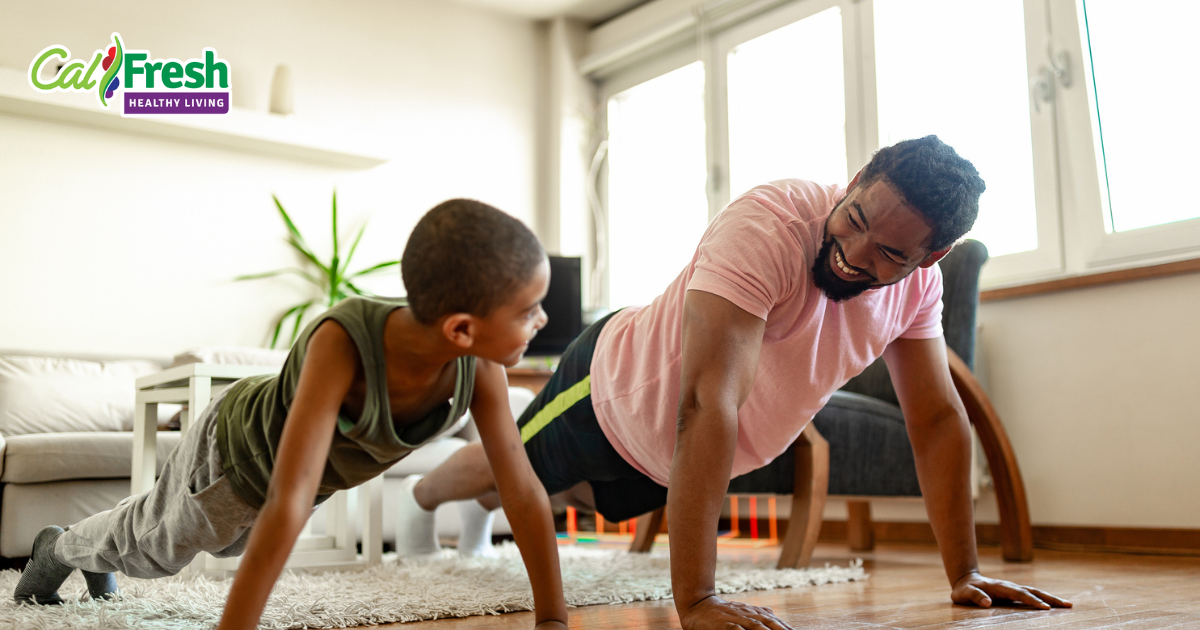 a father and son doing pushups while smiling at each other